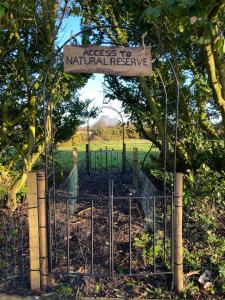 a gate with a sign that reads access to natural reserve at The Lodge in Walberswick