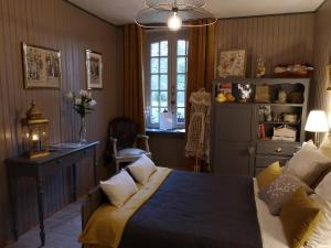 een slaapkamer met een bed, een bureau en een raam bij Manoir de l'Alleu in La Chapelle-Chaussée
