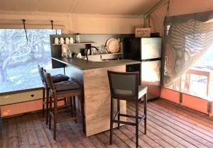 a kitchen with a counter and chairs in a room at GIFFORD private Island GLAMPING boat ride included in Mahone Bay