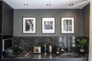a kitchen with a sink and pictures on the wall at Amazing Oasis in heart Of Palermo Hollywood -C1A- in Buenos Aires