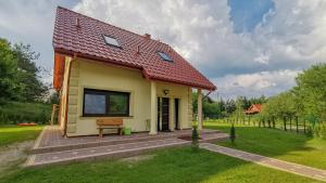 a small yellow house with a red roof at Luksusowe domy na Mazurach nad jeziorem 2 in Kruklanki