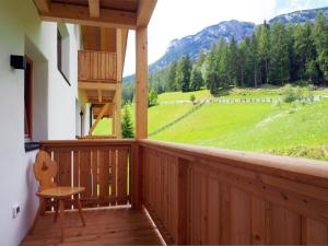 a porch with a chair and a view of a field at Pension Rungg in Badia