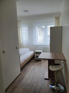 Habitación con cama, mesa y ventana en Hotel Schneider Apartaments, en Langenhagen