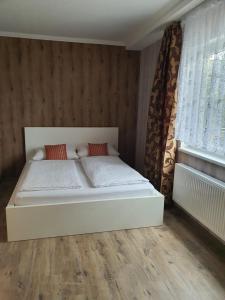a white bed in a room with a window at Hotel Schneider Apartaments in Langenhagen
