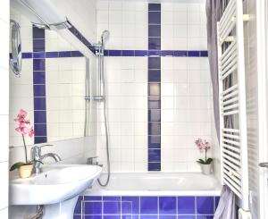 y baño con lavabo y paredes de azulejos azules y blancos. en 834 - Spacious flat in Paris Olympic Games 2024, en París