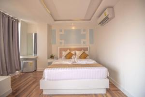 a bedroom with a large white bed in a room at Hak Huot Hotel I in Krong Poi Pet