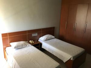 a hotel room with two beds and a cabinet at MIX APART Hotel in Brasília