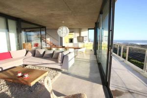 a living room with a couch and a table at VAME Beachfront in Yzerfontein +17 photos