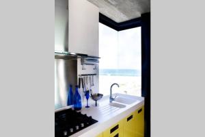 a kitchen with a sink and a counter with a window at VAME Beachfront in Yzerfontein