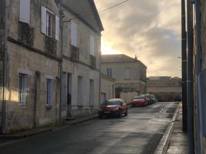 une rue avec des voitures garées sur le côté d'un bâtiment dans l'établissement LES APPART's DES THERMES, à Rochefort