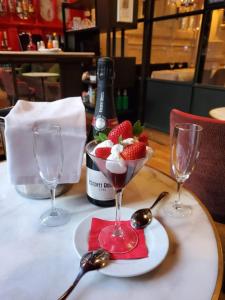 a white plate topped with strawberries and a glass of wine at Hotel Market in Barcelona