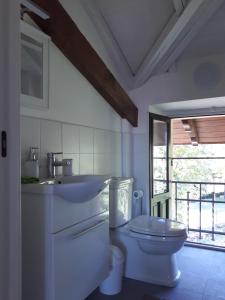 ein weißes Bad mit einem WC und einem Waschbecken in der Unterkunft Villa Peachey (Picci), Grazioso Appartamento in Stresa