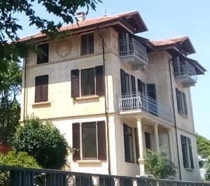 ein großes weißes Haus mit Balkonen und einem Zaun in der Unterkunft Villa Peachey (Picci), Grazioso Appartamento in Stresa