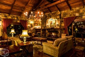 a living room with a couch and a fireplace at Heysbrook Estate - Luxurious lodges in a private valley in Waterval-Onder