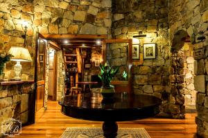 a room with a table in a stone wall at Heysbrook Estate - Luxurious lodges in a private valley in Waterval-Onder