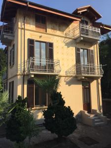 ein gelbes Haus mit Balkon an der Seite in der Unterkunft Villa Peachey (Picci), Grazioso Appartamento in Stresa