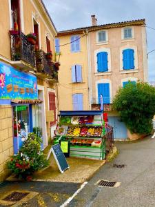 a fruit and vegetable stand in front of a building at Les Arcades in Villecroze