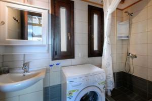 W łazience znajduje się pralka i umywalka. w obiekcie Katevi Luxury Seafront Villa w mieście Ierissós +27 zdjęć