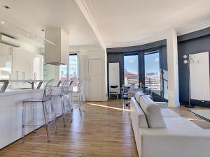 una cucina e un soggiorno con divano e bancone di Nestor&Jeeves - LES AIGLES - Very close sea - Top floor - Luxurious a Nizza