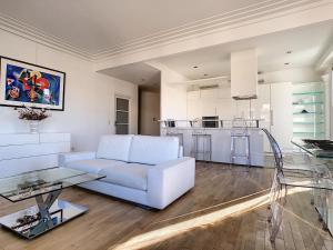 a living room with a white couch and a kitchen at Nestor&Jeeves - LES AIGLES - Very close sea - Top floor - Luxurious in Nice