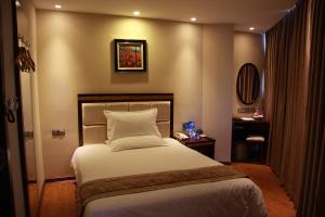 A bed or beds in a room at GreenTree Inn Guangdong Shantou Chengjiang Road Business Hotel