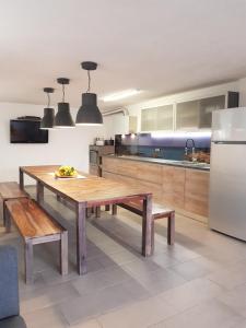 a kitchen with a wooden table and a refrigerator at Casa del Sole Irgoli - BIKERS HOME in Irgoli +36 photos
