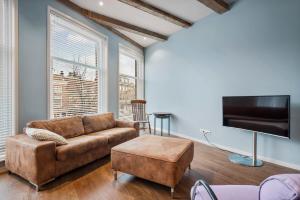 a living room with a couch and a flat screen tv at Five Churches View apartments in Haarlem