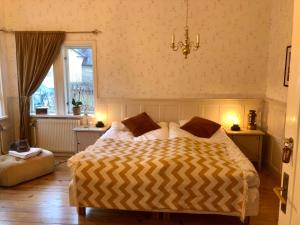 1 dormitorio con cama, ventana y lámpara de araña en Pensionat Kanalvillan en Väddö