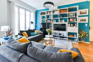 a living room with blue walls and a gray couch at Le Joffre in Nice