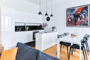 a kitchen and dining room with a white table and chairs at Le Joffre in Nice