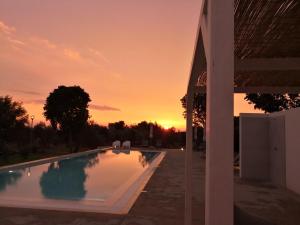 a swimming pool with a sunset in the background at Dimora di Dante in Chiaramonte Gulfi