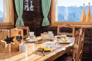 una mesa de madera con platos de comida. en Hotel Slalom en Bettmeralp