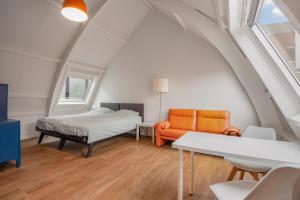 Cette chambre mansardée comprend un lit et un canapé. dans l'établissement Five Churches View apartments, à Haarlem