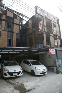 two white cars are parked in a garage at 9 Hostel in Chiang Mai
