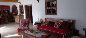 a living room with a red couch and a table at Casa da Bisa - Santa Maria - Açores in Santa Bárbara
