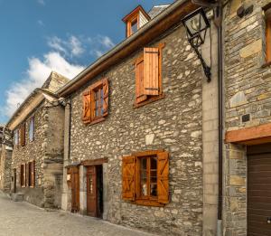 ベトレンにあるCasa Rural "Casa Chin", Val d'Aranの通りに建つ木窓付きの石造りの建物