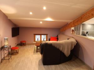 a bedroom with a bed and a living room at GITES LES MAISONS ROUGES in Jasseron