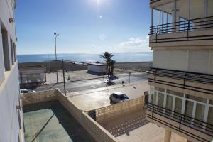 een balkon met uitzicht op een gebouw en het strand bij 020 - Senya Gran Playa 001 - comfortHOLIDAYS in Santa Pola