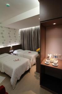 a hotel room with two beds with flowers on them at Tai Ichi Hotel Kuala Lumpur in Kuala Lumpur