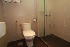 W łazience znajduje się toaleta i przeszklony prysznic. w obiekcie Tai Ichi Hotel Kuala Lumpur w Kuala Lumpur