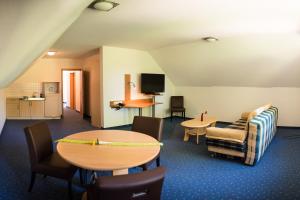 a room with tables and chairs and a tv at Hotel Heilemann in Wietmarschen