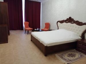 a bedroom with a bed and two red chairs at Филадэльфия in Kislovodsk