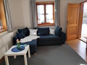 sala de estar con sofá azul y mesa en Ferienhaus Erika, en Garmisch-Partenkirchen