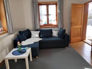 a living room with a blue couch and a table at Ferienhaus Erika in Garmisch-Partenkirchen