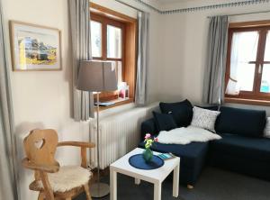 - un salon avec un canapé bleu et une chaise dans l'établissement Ferienhaus Erika, à Garmisch-Partenkirchen