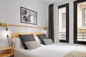 a bedroom with a large bed and a large window at Hostal Arriazu in Pamplona