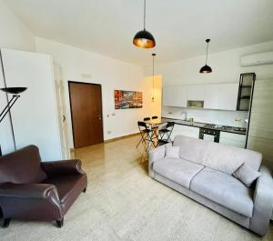 uma sala de estar com um sofá e uma cadeira e uma cozinha em INTERNO DIECI em Roma