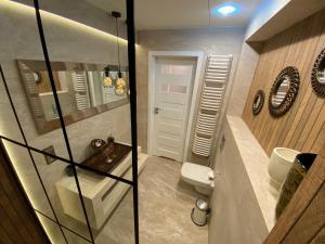 a bathroom with a toilet and a glass shower at P&J Apartments Lubicz in Kraków
