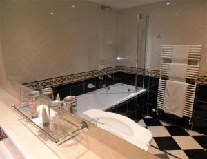 a bathroom with a toilet and a bath tub at Hollies Hotel in Martock
