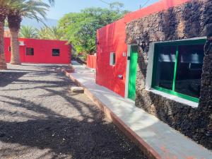 un edificio rojo y verde junto a una pared en Pensión Casa Trudo, en La Frontera